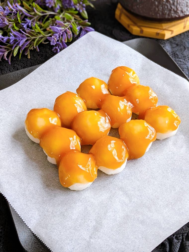 器にのせたお団子にみたらしをつけたところ