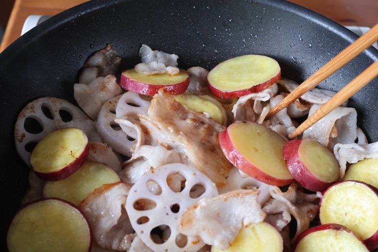 豚肉とさつまいもとれんこんを炒めている