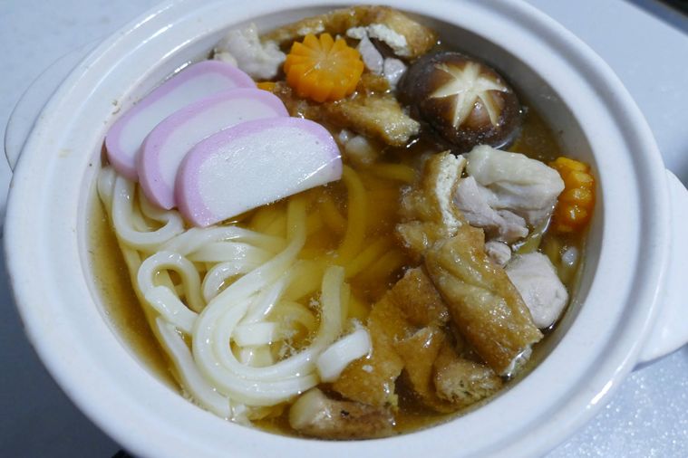 鍋に冷凍うどんとかまぼこを入れた様子