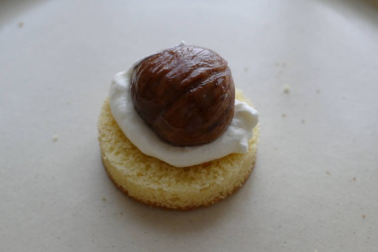 スポンジケーキにホイップクリームと栗の渋皮煮をのせた様子
