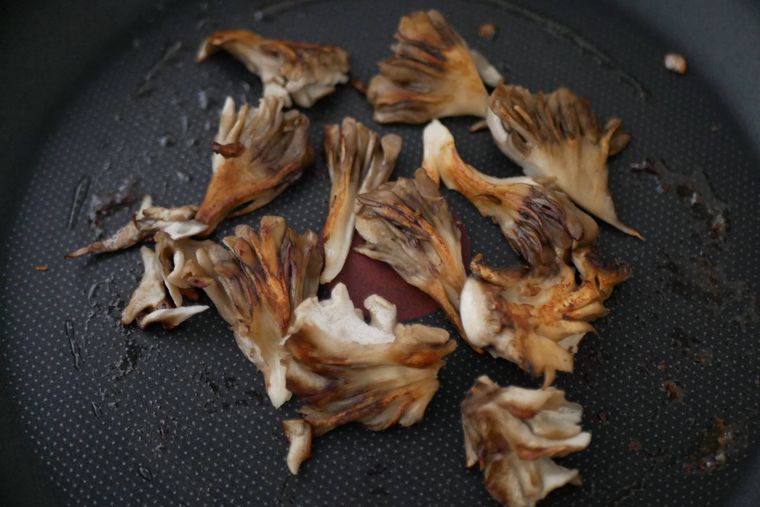 フライパンにバターを溶かしまいたけを炒める様子