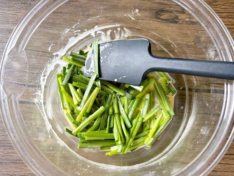 チヂミ生地にニラを加えて混ぜる様子