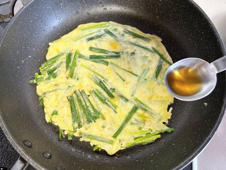 ニラ入りのチヂミ生地にごま油を入れる様子