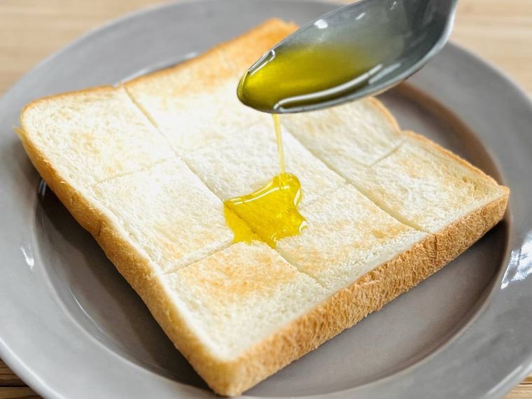 トーストにオリーブオイルをかけている様子