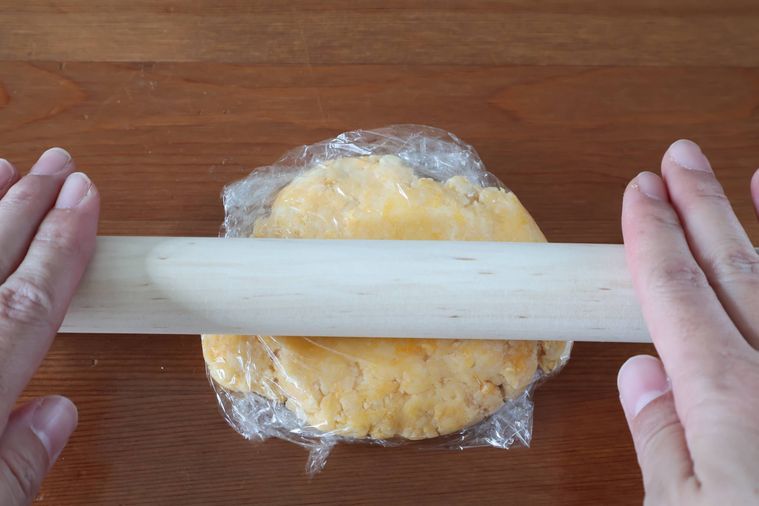 ラップに包んだ生地を伸ばしている