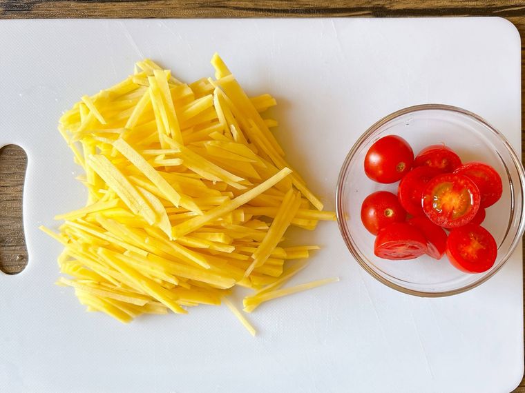 まな板におかれたカットしたじゃがいも、ミニトマト