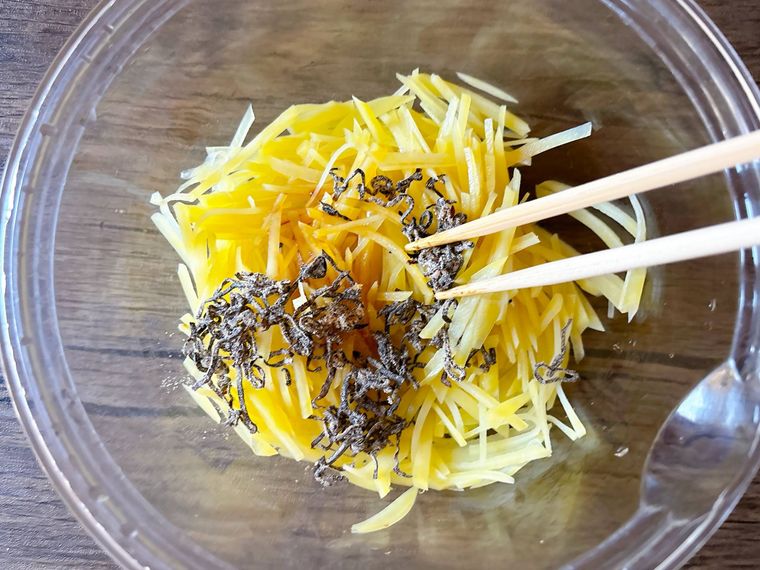 じゃがいもと調味料、塩こんぶを和える様子