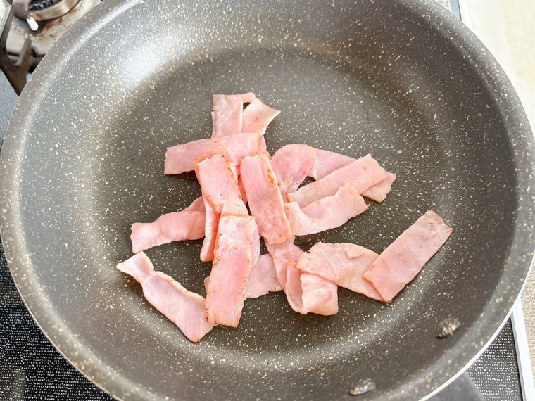 フライパンでベーコンを炒める様子
