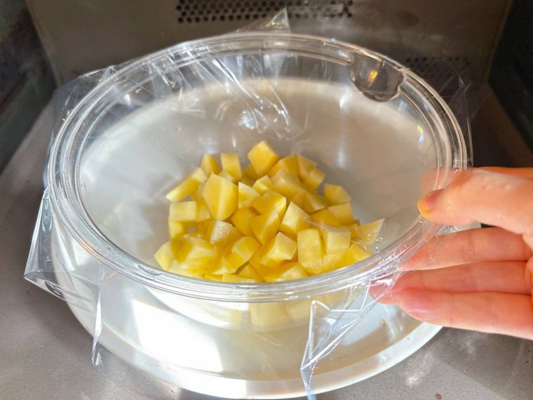 耐熱ボウルに入ったじゃがいもを電子レンジで加熱する様子