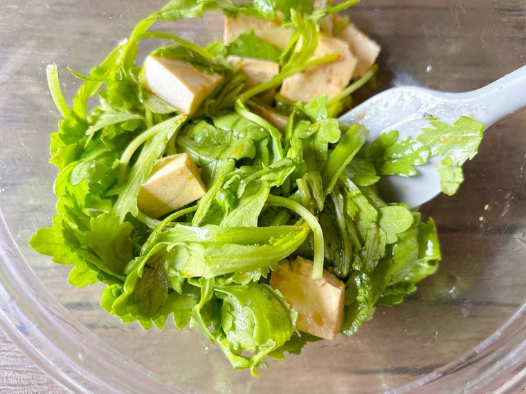春菊と木綿豆腐、ドレッシングを和える様子