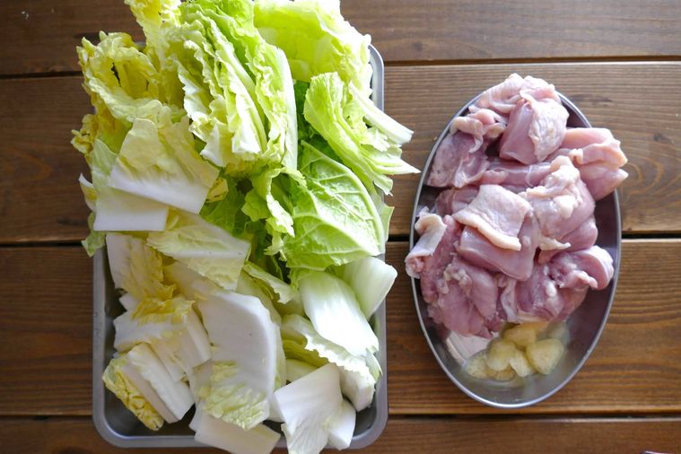 切った白菜と鶏もも肉、にんにくが並ぶ様子