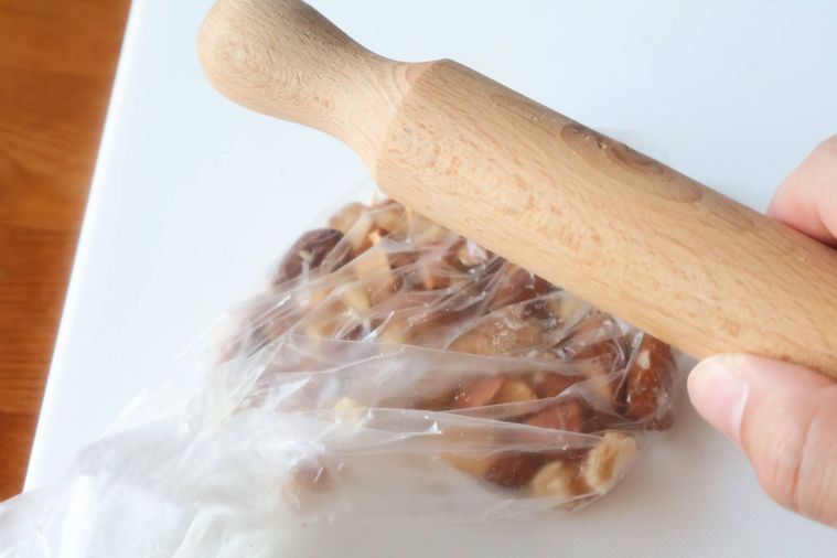 ポリ袋に入れたナッツを叩いている