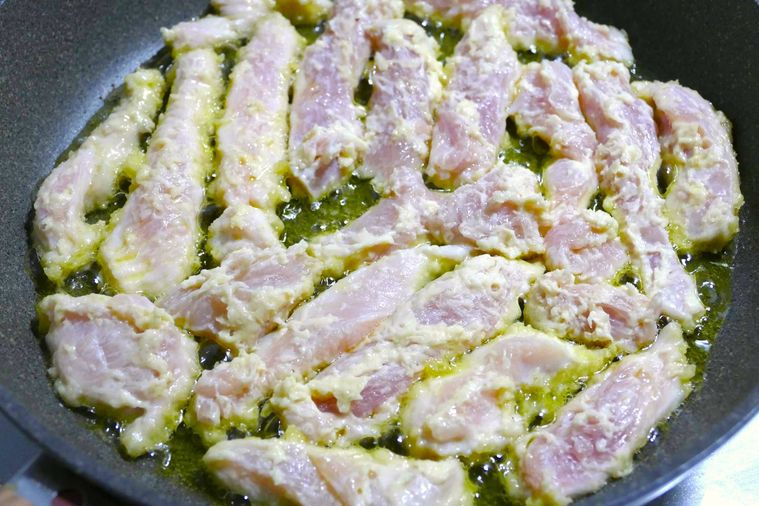 フライパンに鶏むね肉を広げて並べた様子