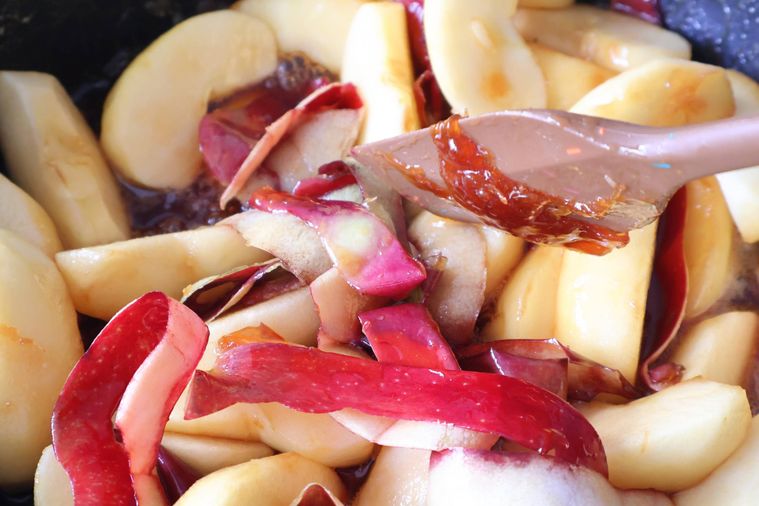 りんごとりんごの皮をカラメルに混ぜている