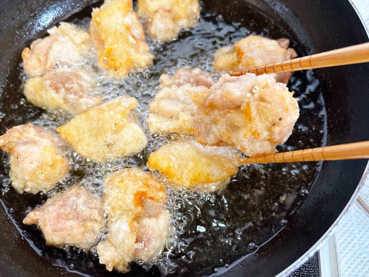 唐揚げを油からあげる様子