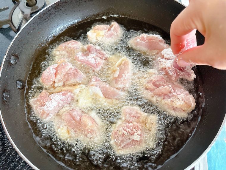 鶏もも肉を油で揚げる様子