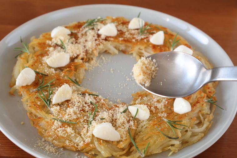 リース型のガレットに粉チーズをかけている