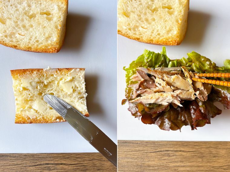 フランスパンにバターを塗りサラダ菜とほぐし鯖を挟む様子