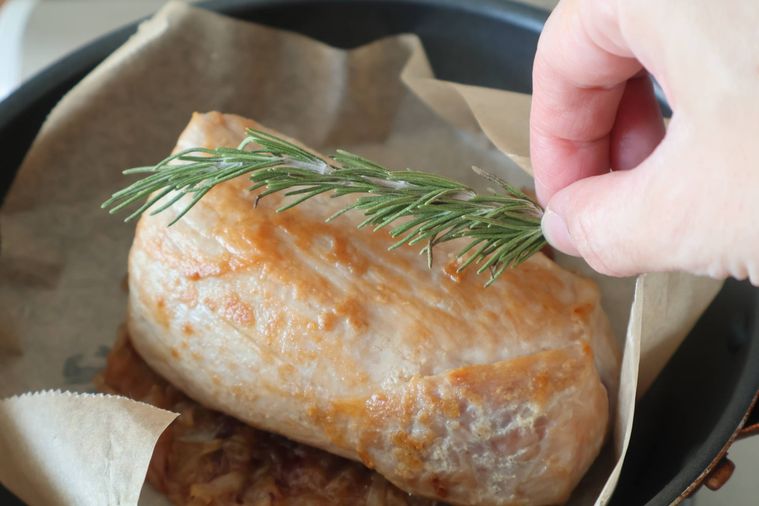 豚肉にローズマリーをのせている