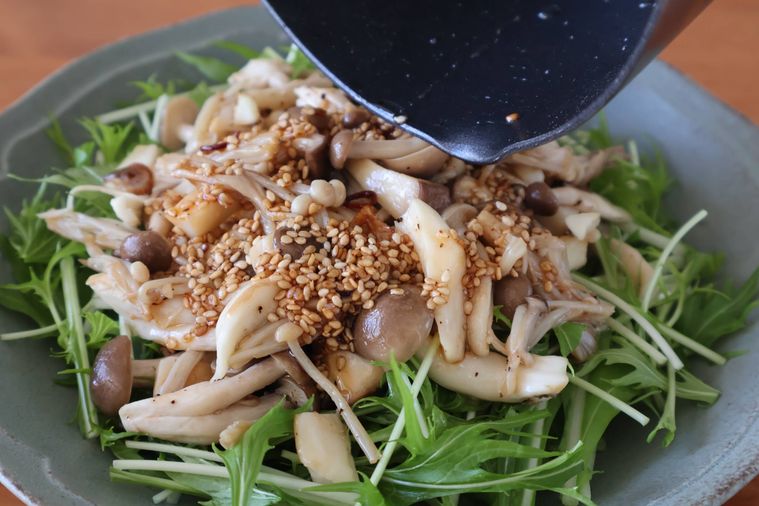 サラダに鍋からソースをかけている