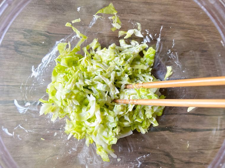 キャベツと調味料を和える様子