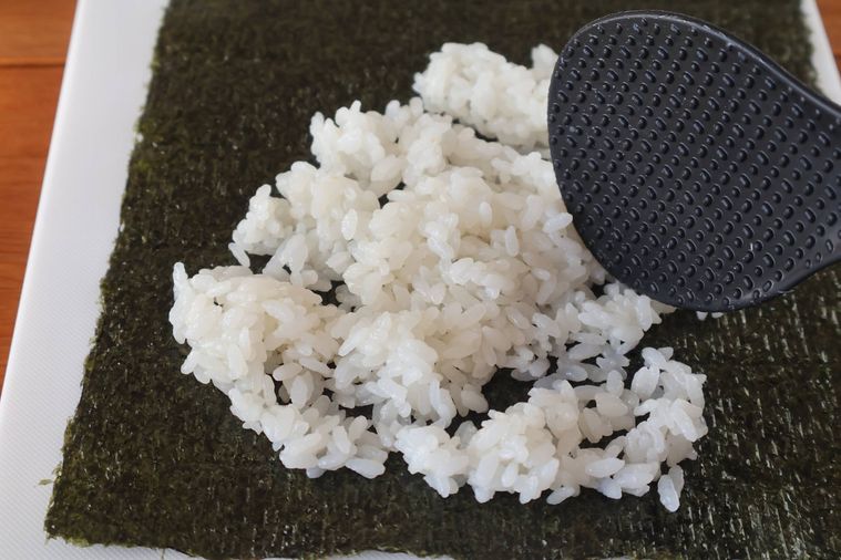 海苔に酢飯を広げている