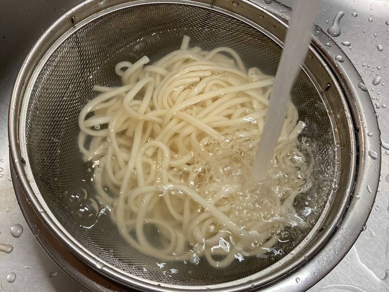 うどんを冷水でしめる様子