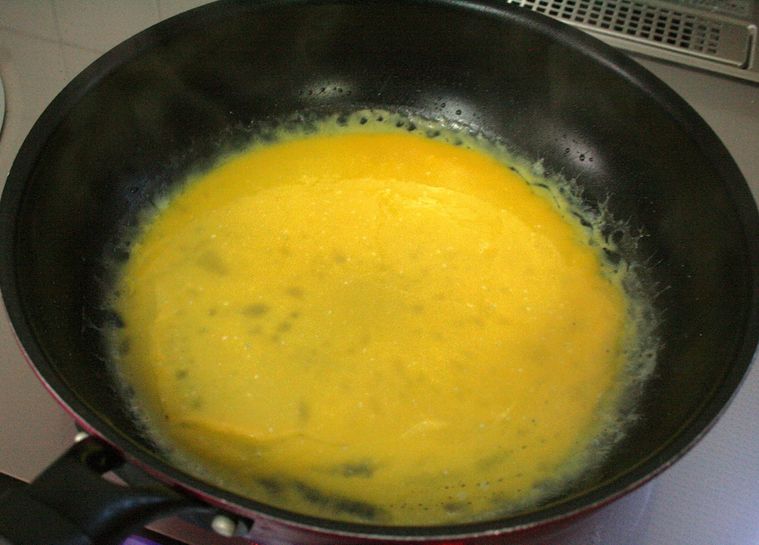 フライパンで卵液を焼いている様子