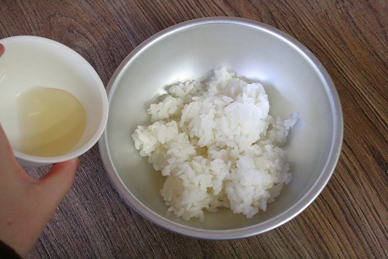 ごはんにすし酢をかけようとしている様子