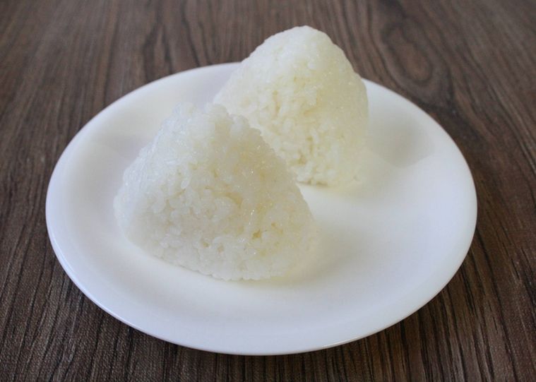 白い皿に寿司飯のおにぎりが2つ並んでいる様子