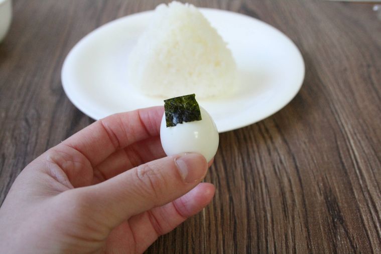 うずら卵に焼き海苔を貼りつけている様子