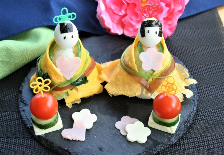 黒い皿にお雛様寿司が盛られている様子