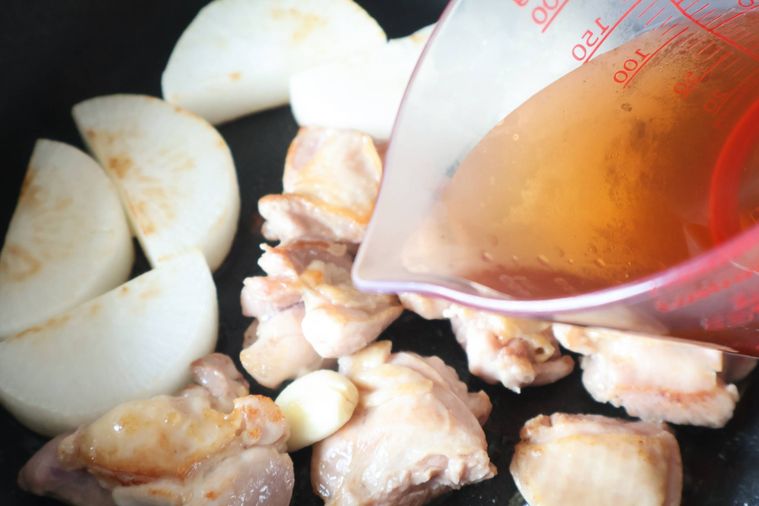 フライパンに調味料を加えている