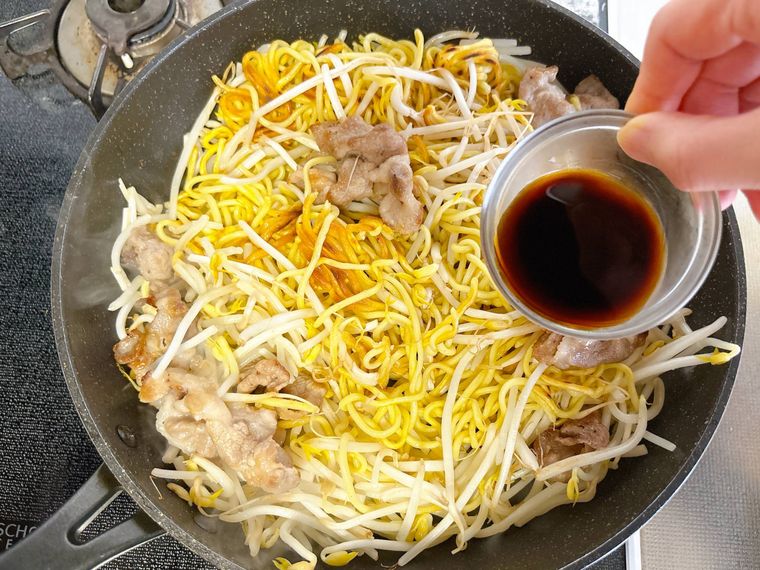 フライパンに調味料を入れる様子