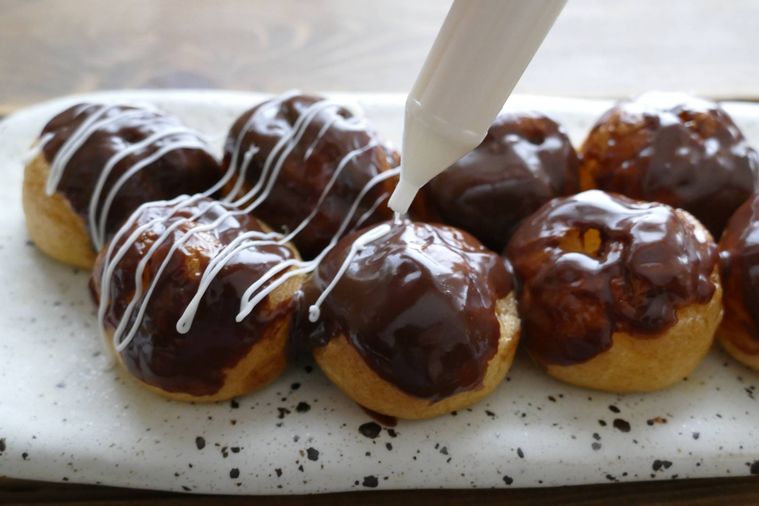 ホワイトチョコペンでマヨネーズ風のデコレーションをする様子