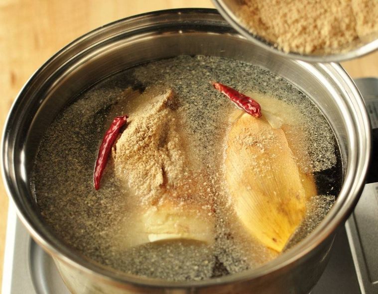 たけのこが入った鍋の中に鷹の爪、米ぬかが振り入れられている