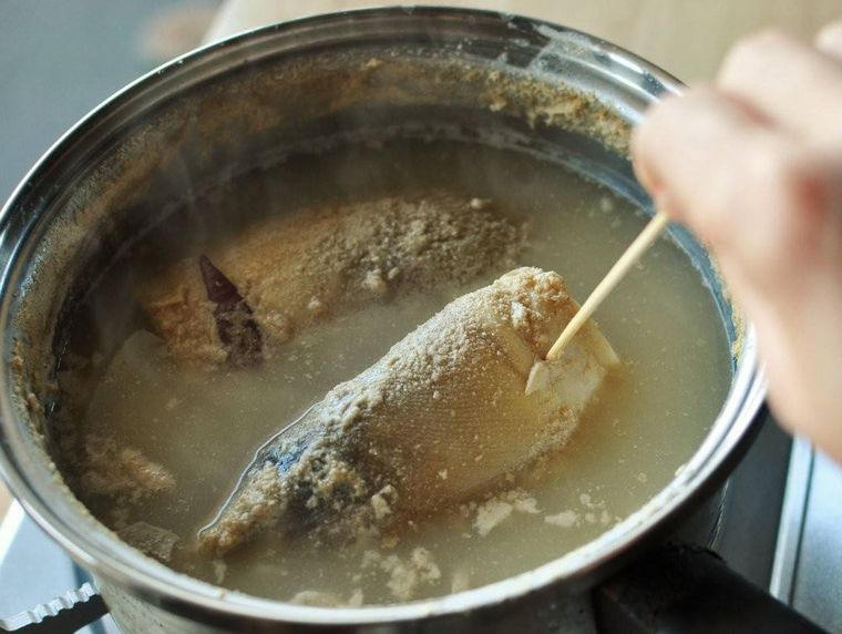 鍋の中で串を刺されているゆでたけのこ