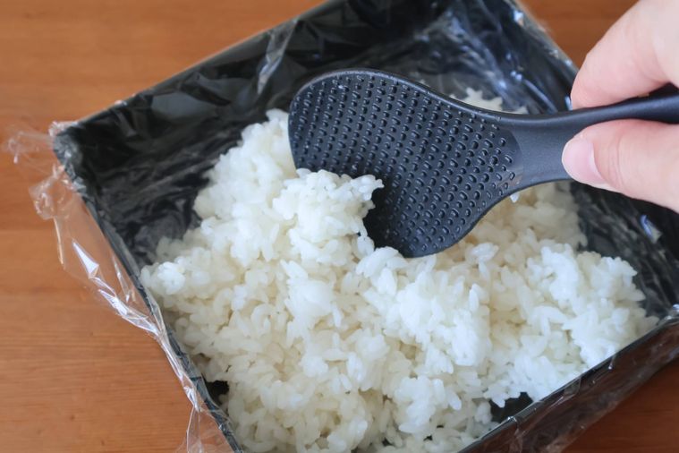 重箱に酢飯を入れている