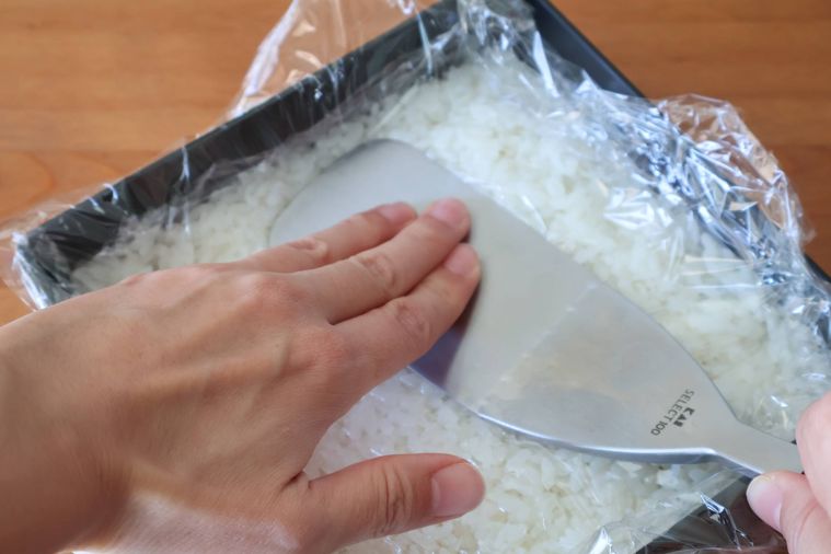 ターナーで酢飯を押さえている