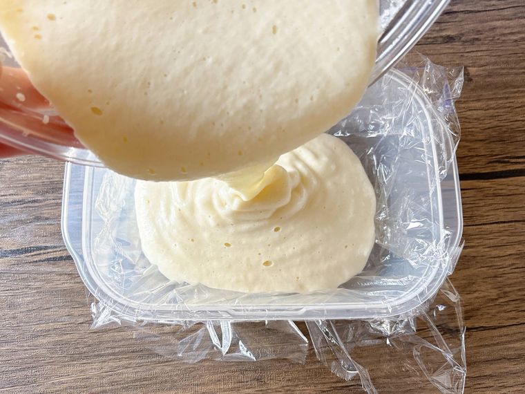 ラップを敷いた保存容器にりんごのペーストを流し入れる様子