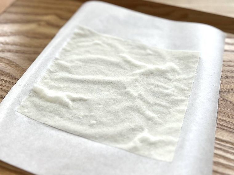 水にくぐらせた春巻きの皮をクッキングシートの上に置いた様子