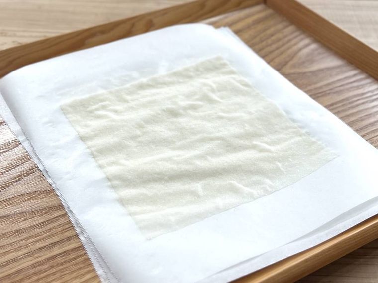 水にくぐらせた春巻きの皮をクッキングシートの上に置いた様子