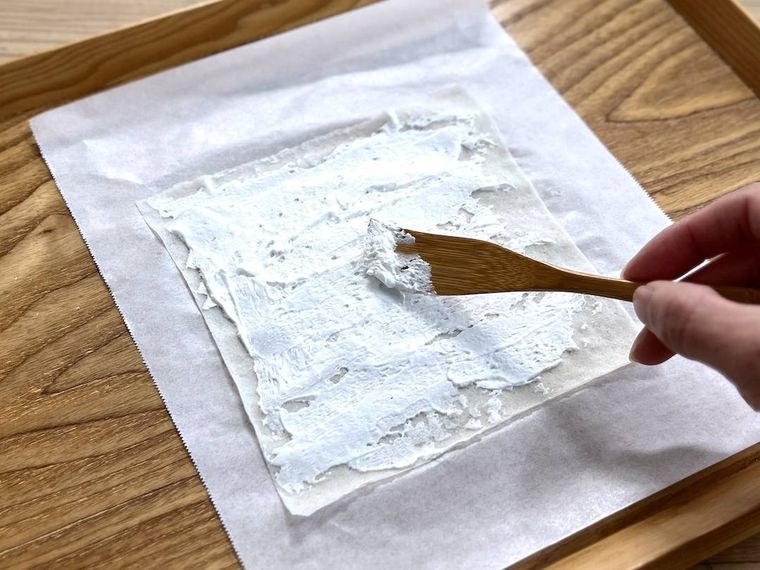 春巻きの皮にホイップクリームを塗っている様子