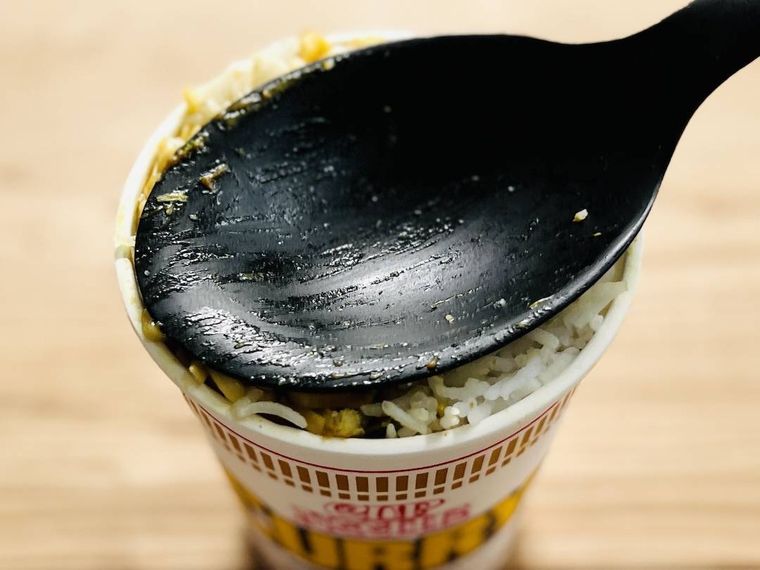 カップにカップヌードル カレーとバスマティライスを押し込んでいる様子