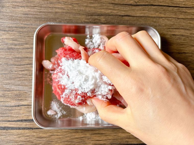 牛肉に片栗粉をまぶす様子