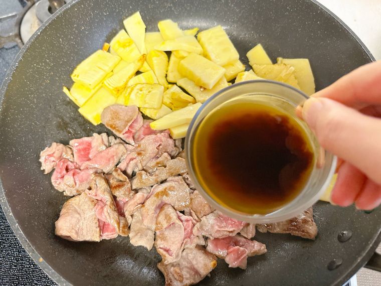 フライパンに調味料を加える様子