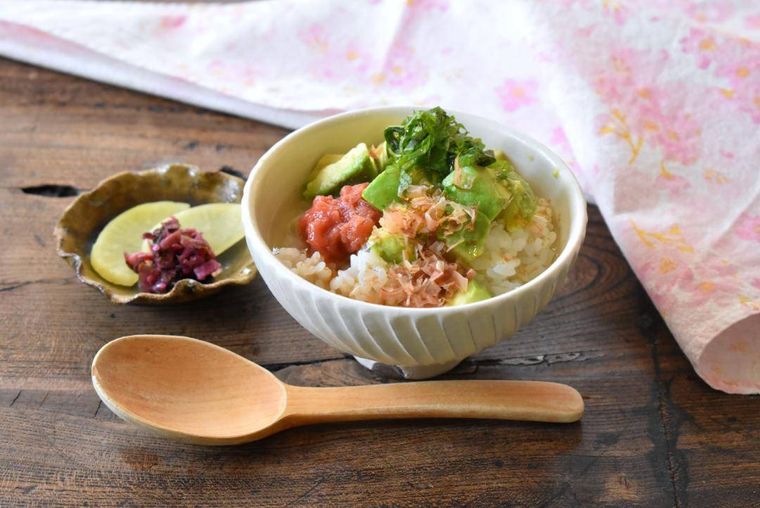 テーブルに置いたアボカド茶漬け、漬物、スプーン