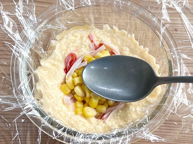 豆腐まんの生地にコーンとカニカマを加えている様子