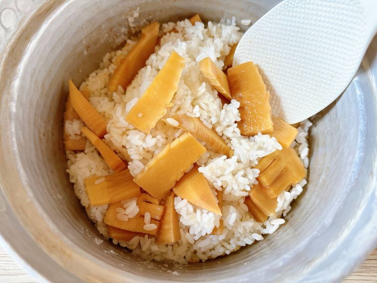 温かいごはんにたけのこを混ぜる様子