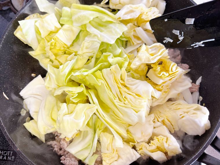 豚ひき肉とキャベツを炒める様子